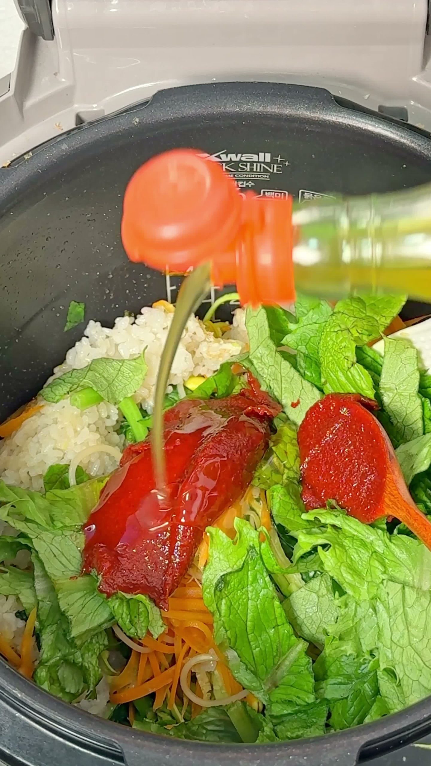 Gochujang sauce being mixed with syrup and sesame oil