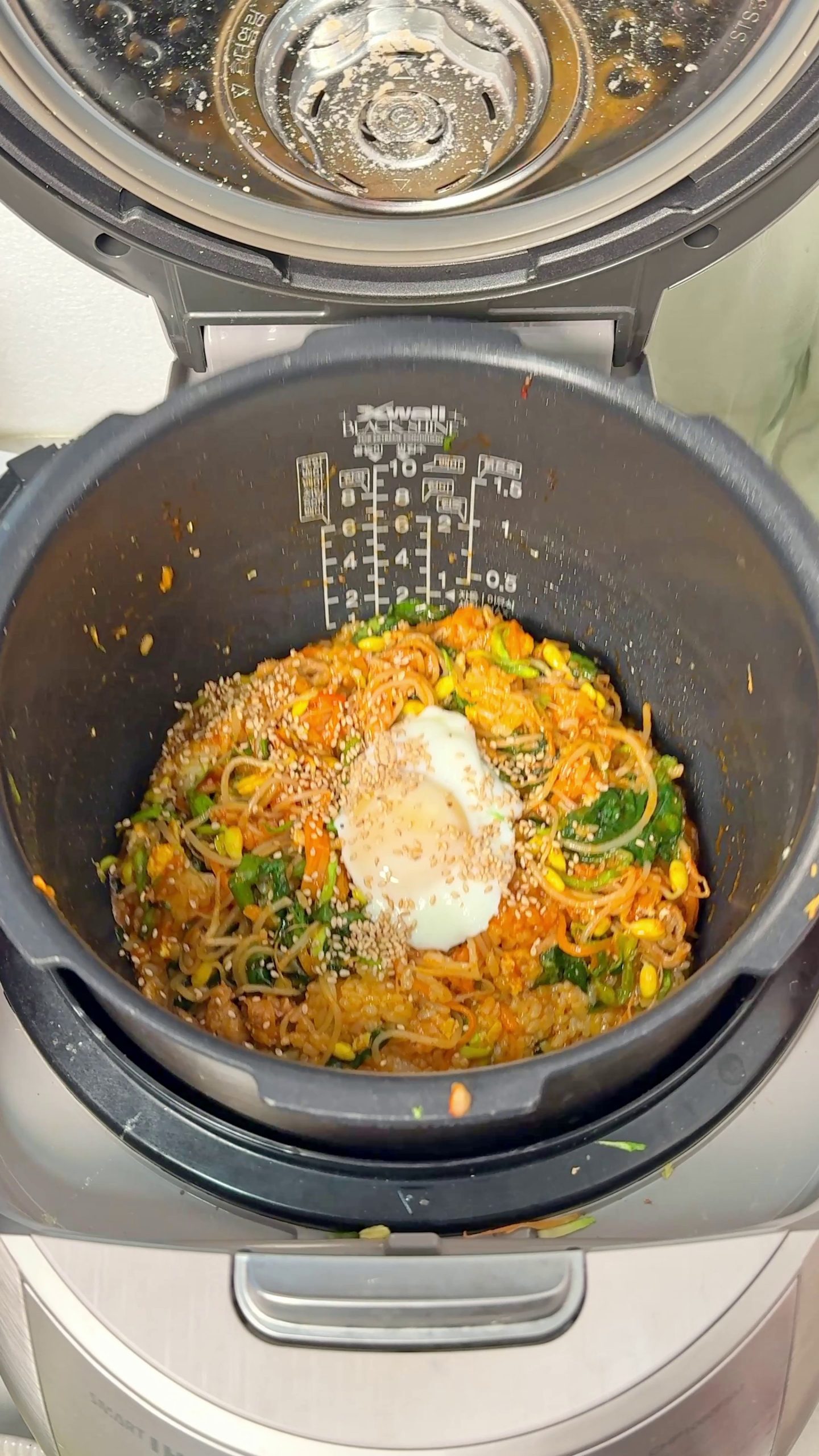 Bibimbap in a rice cooker mixed with beef, vegetables, and fried egg