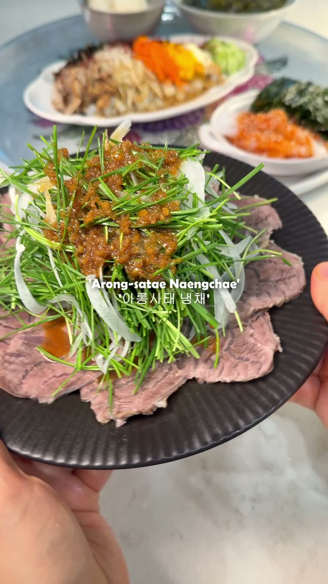 Sliced beef shank plated with garlic chives and onion