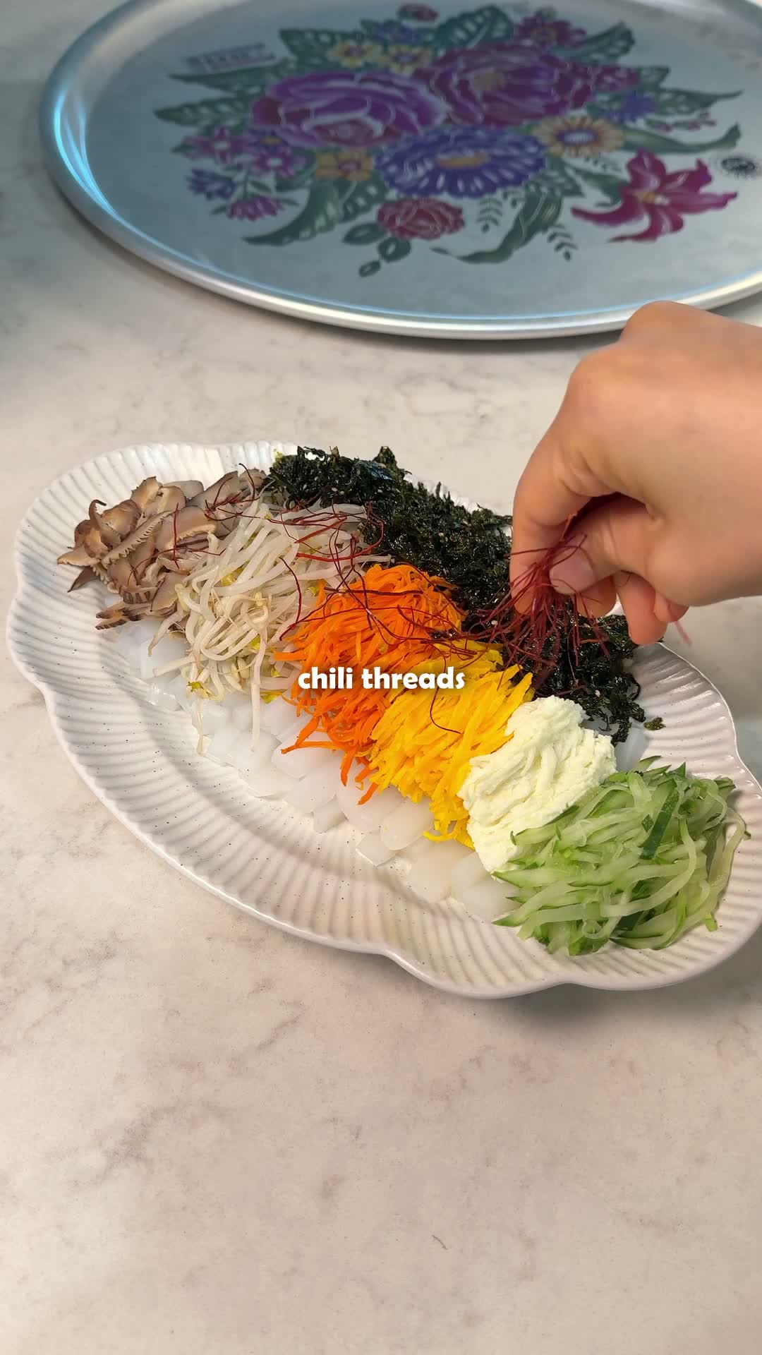 Mung bean jelly salad plated with toppings and red pepper threads