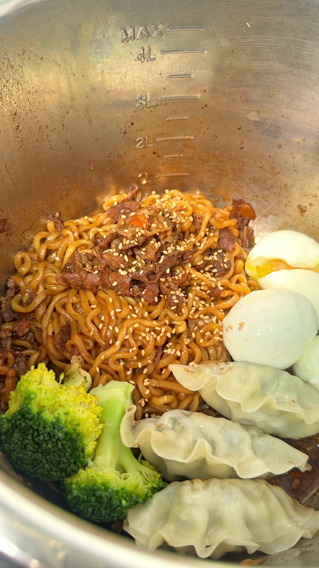 Chapagetti black bean noodles with dumplings, broccoli, and eggs in a pot