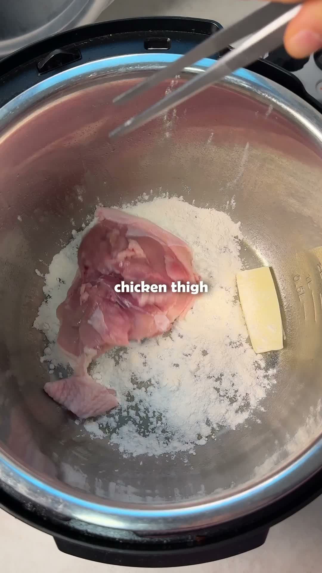 Chicken thigh placed into a pot dusted with flour and butter