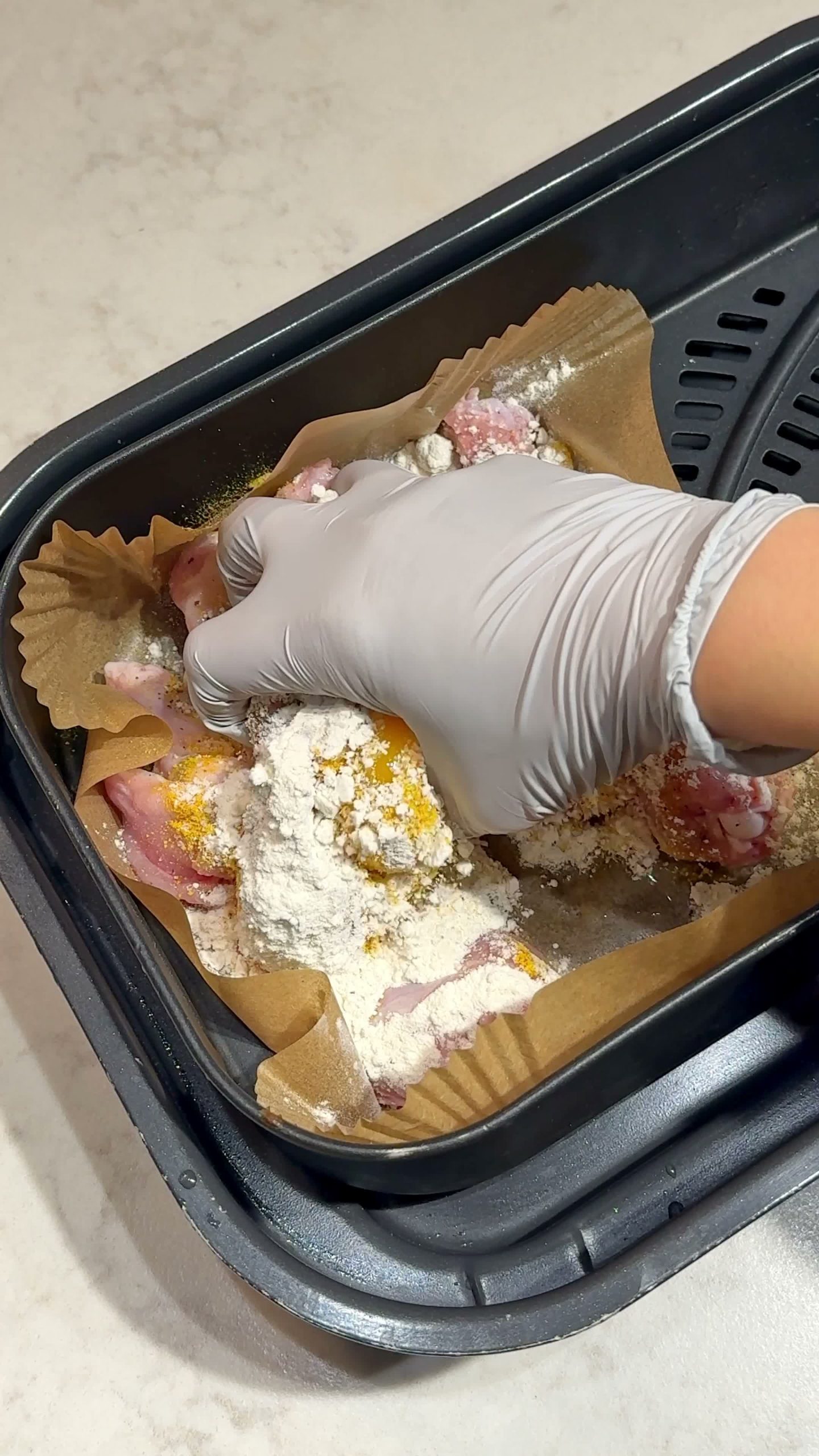 Mixing chicken drumettes with egg, curry powder, and flour