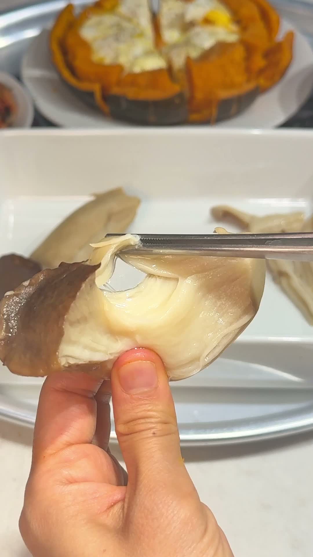 King oyster mushroom being shredded by hand