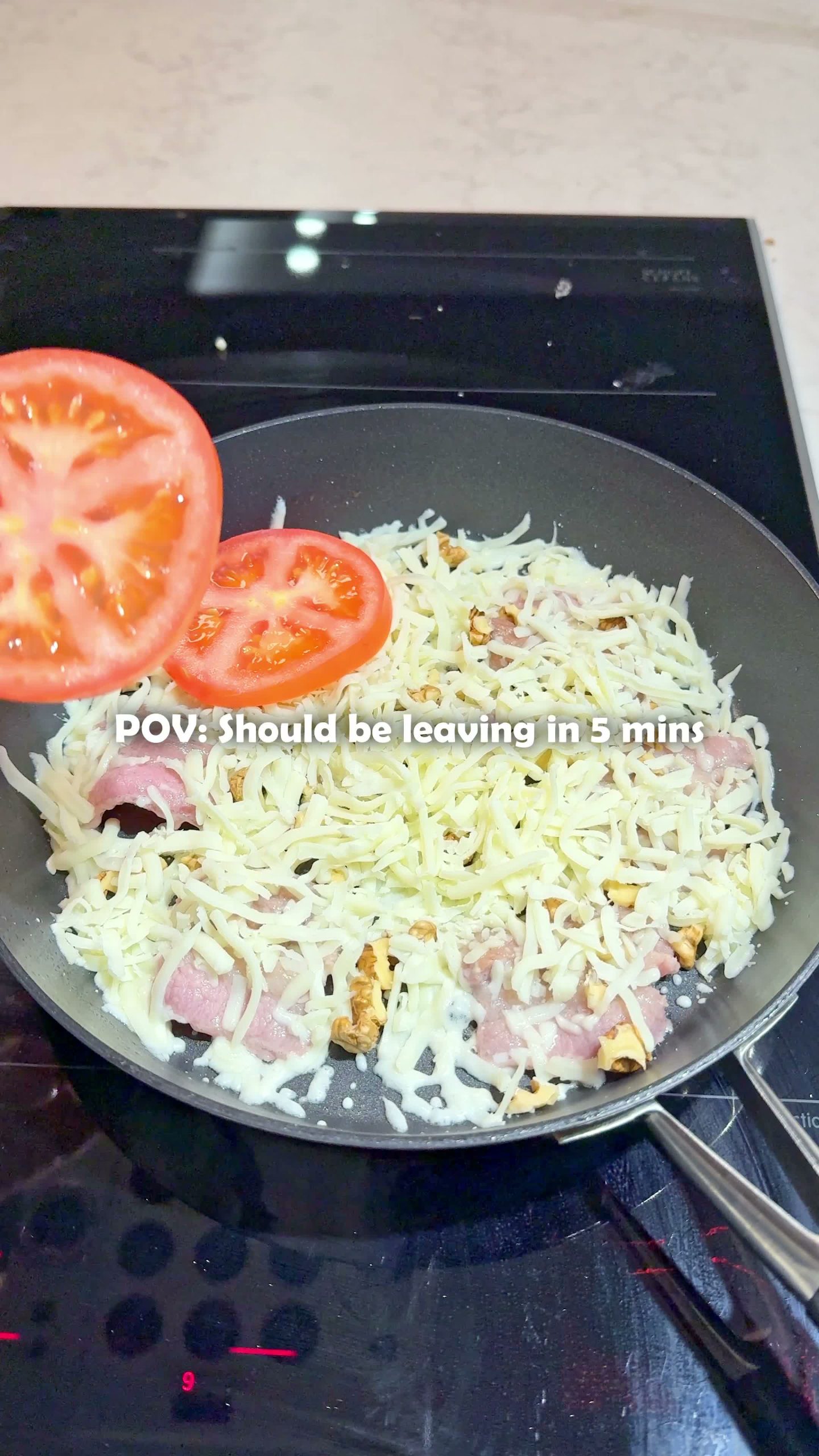 Bacon, cheese, and tomato layered in the pan