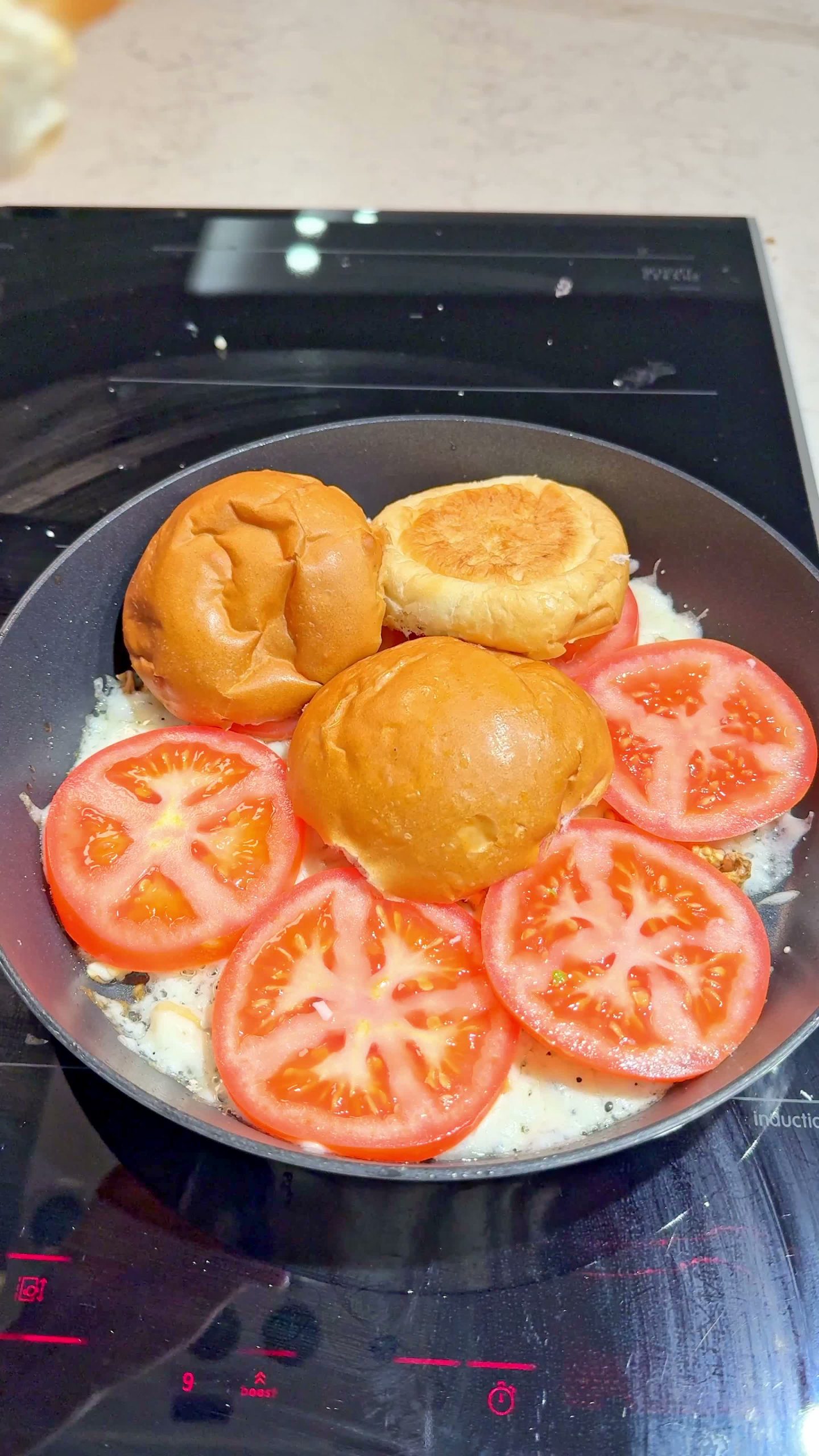 Dinner rolls arranged over the tomato and toppings in the pan