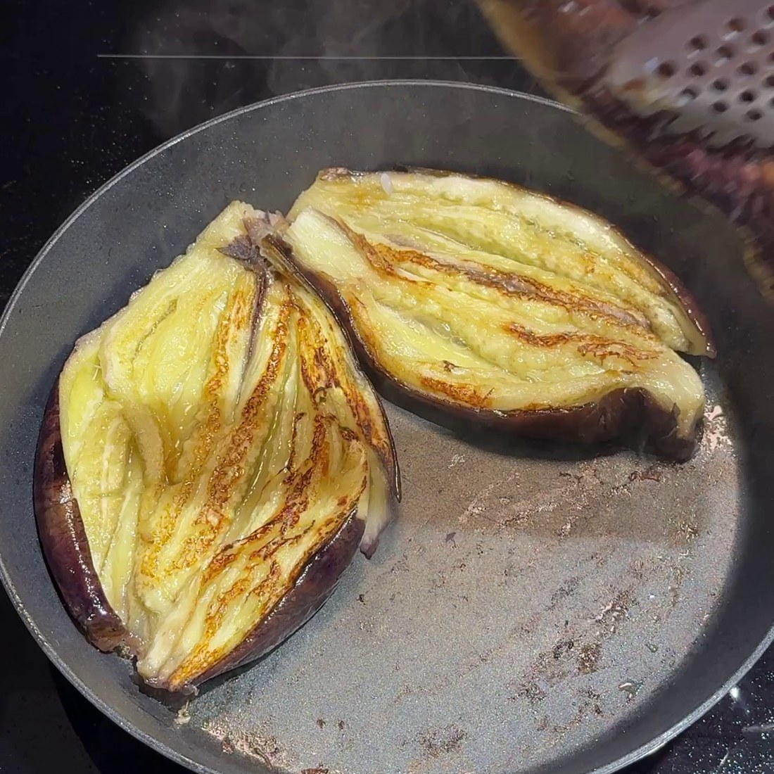 Steamed eggplant halves pan-seared until golden
