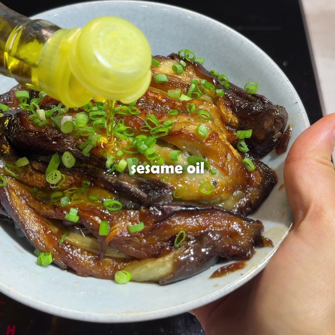 Sesame oil and scallions finished over the rice bowl