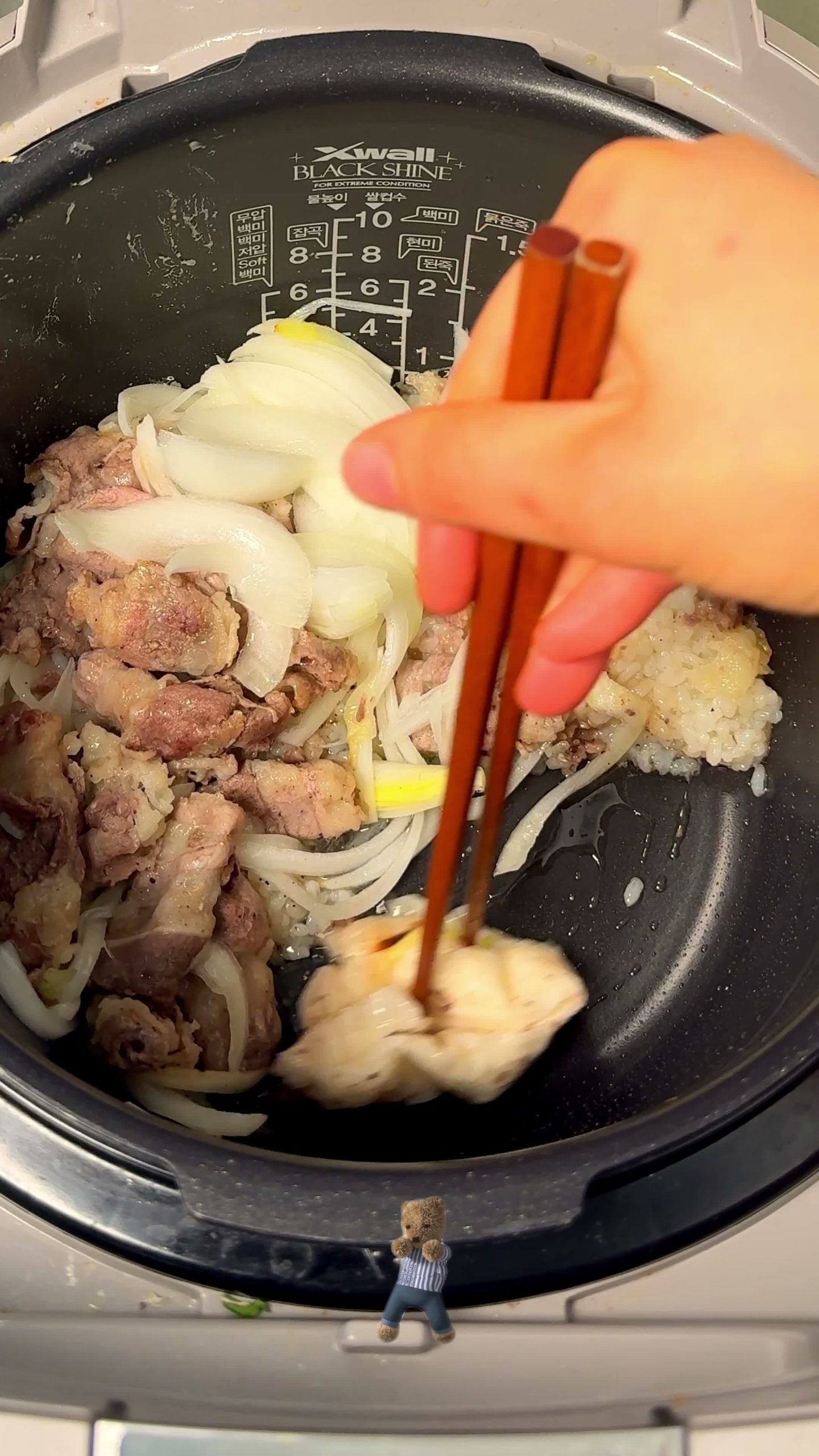 Rice, beef, and onion in the pot before the first steam
