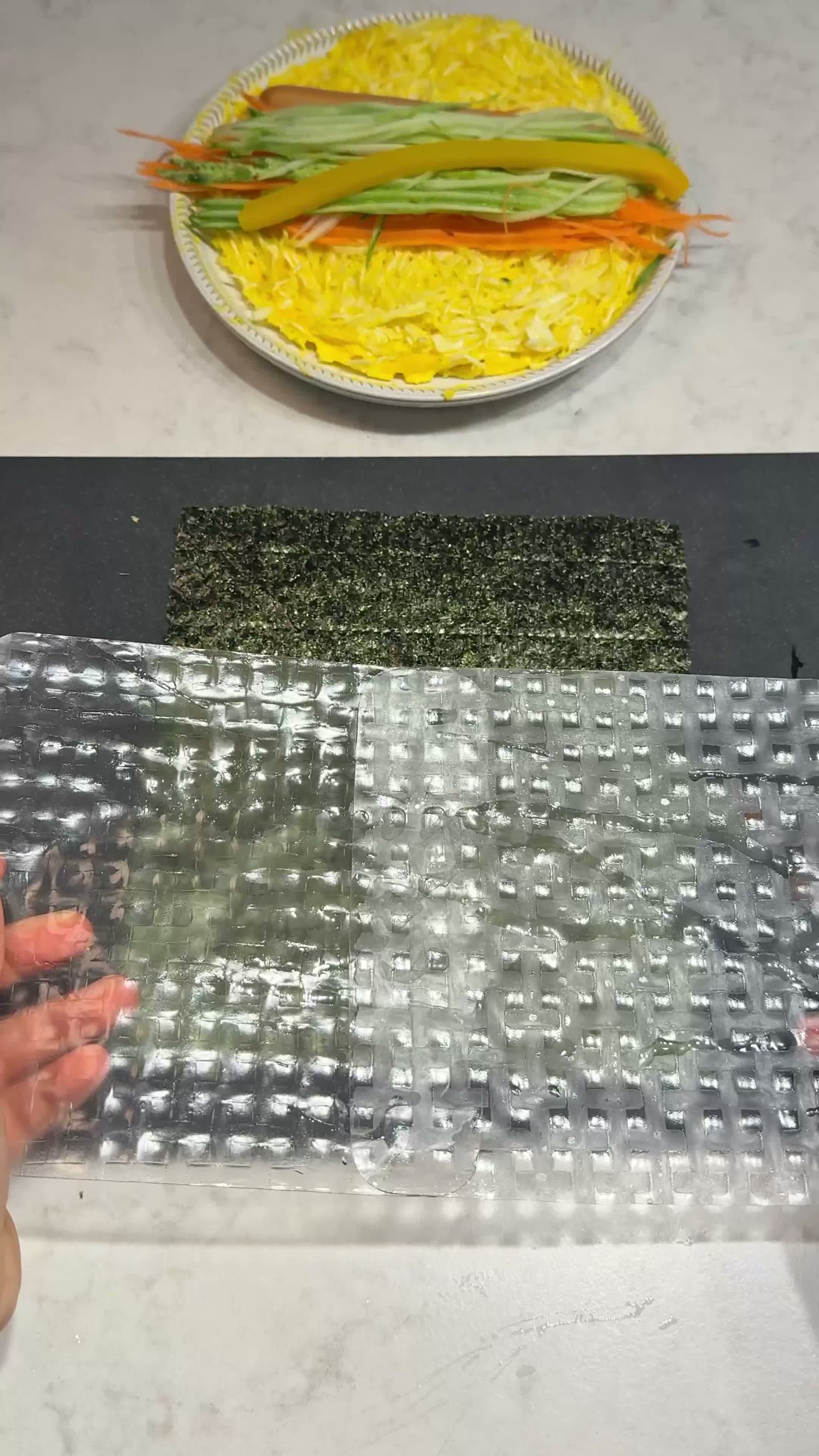 Wetted rice paper laid over a seaweed sheet