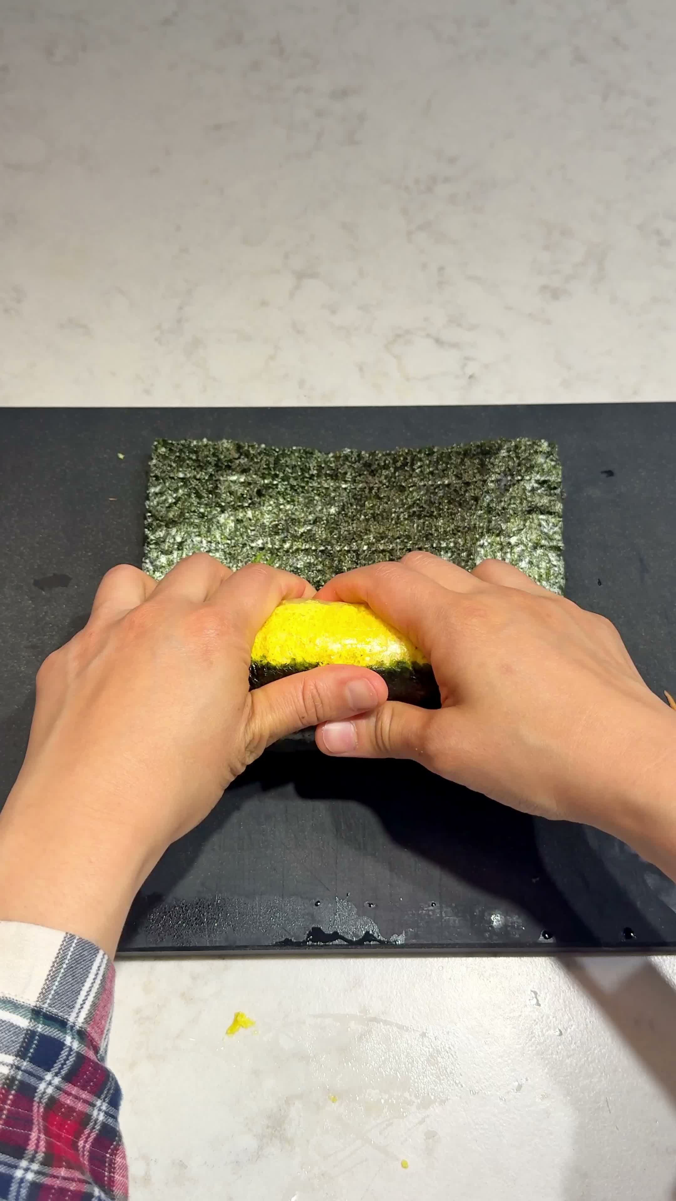 Rolling the egg base up tightly with the seaweed