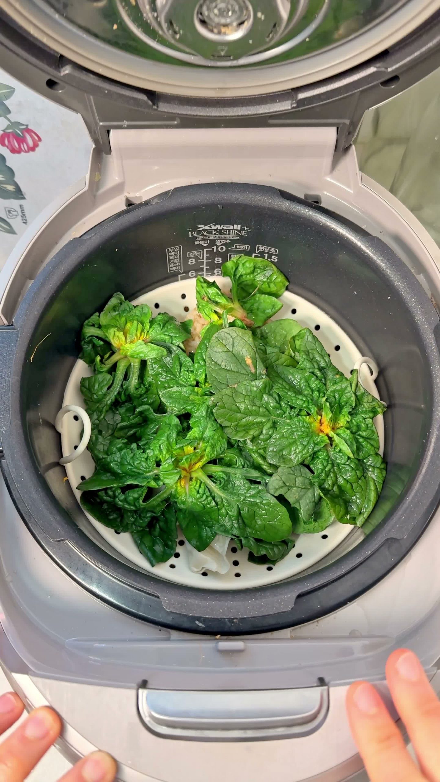 Rice, dumplings, and spinach added to the pot below the steamer tray