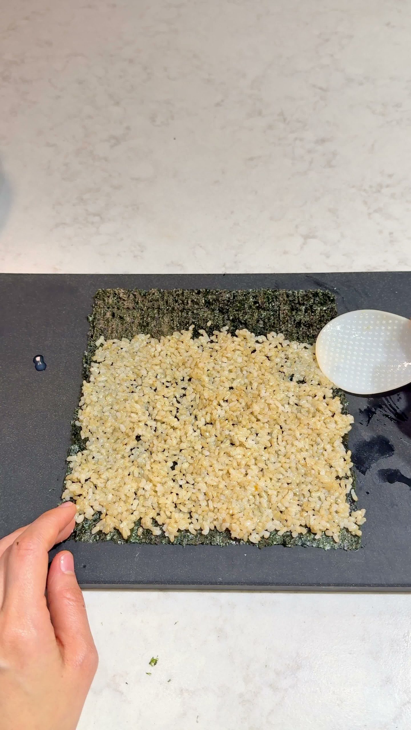 Steamed fillings laid onto rice and seaweed, ready to roll