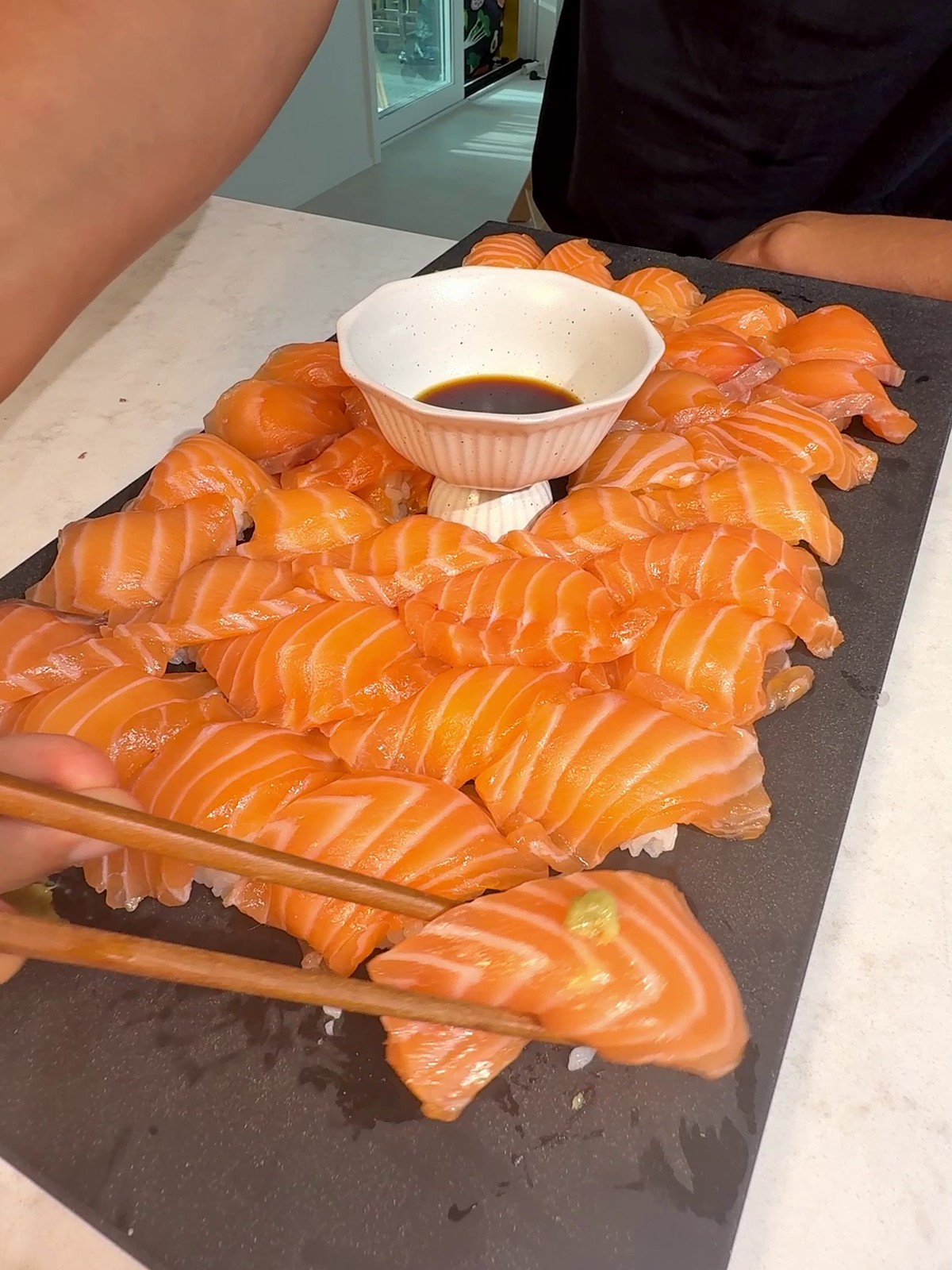 Cured salmon rose sushi arranged around wasabi and soy sauce