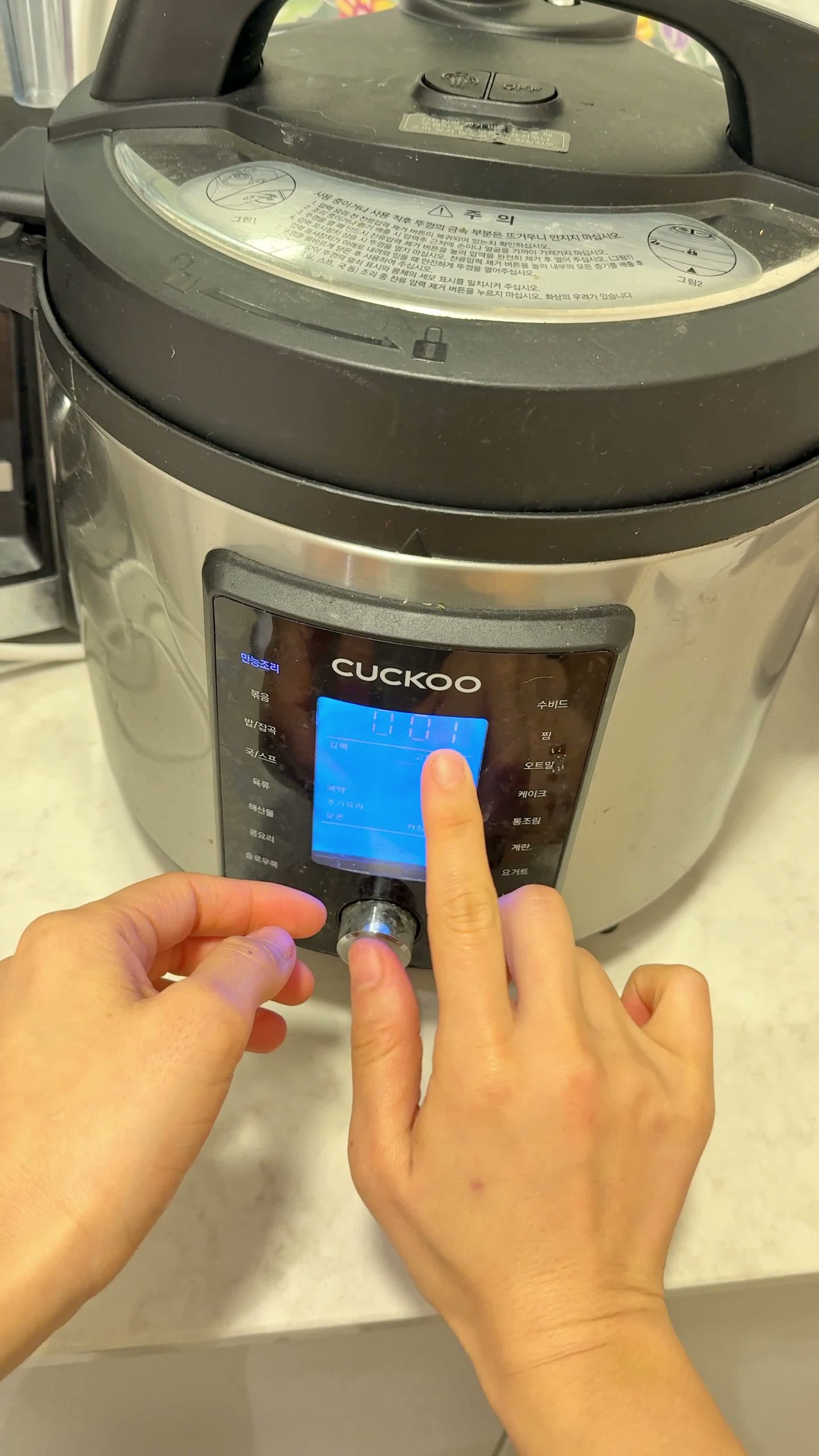 Pressing the quick-release button on the pressure cooker