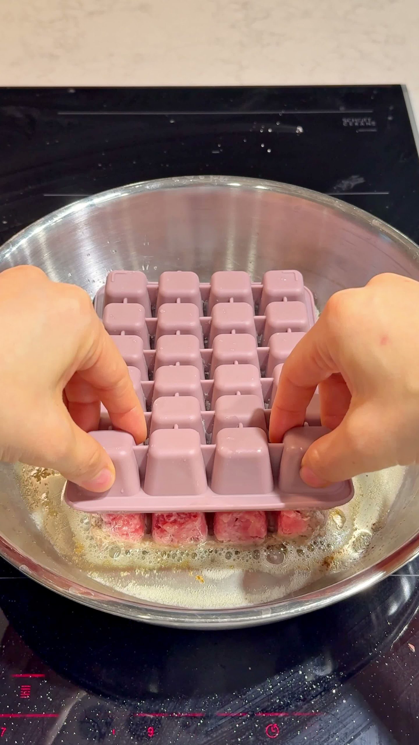 Pressing the meat mixture into a silicone ice cube tray