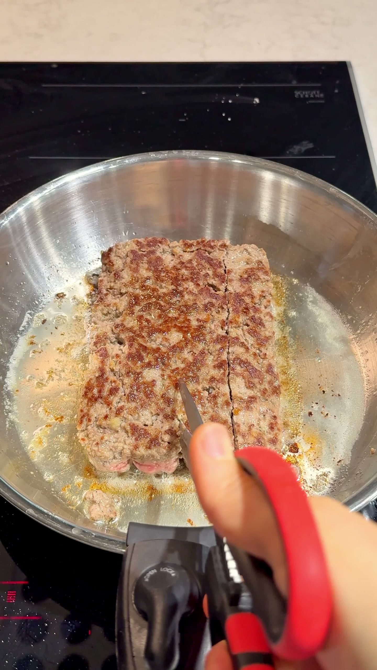 Flipping the tray to release the meatballs onto a buttered pan