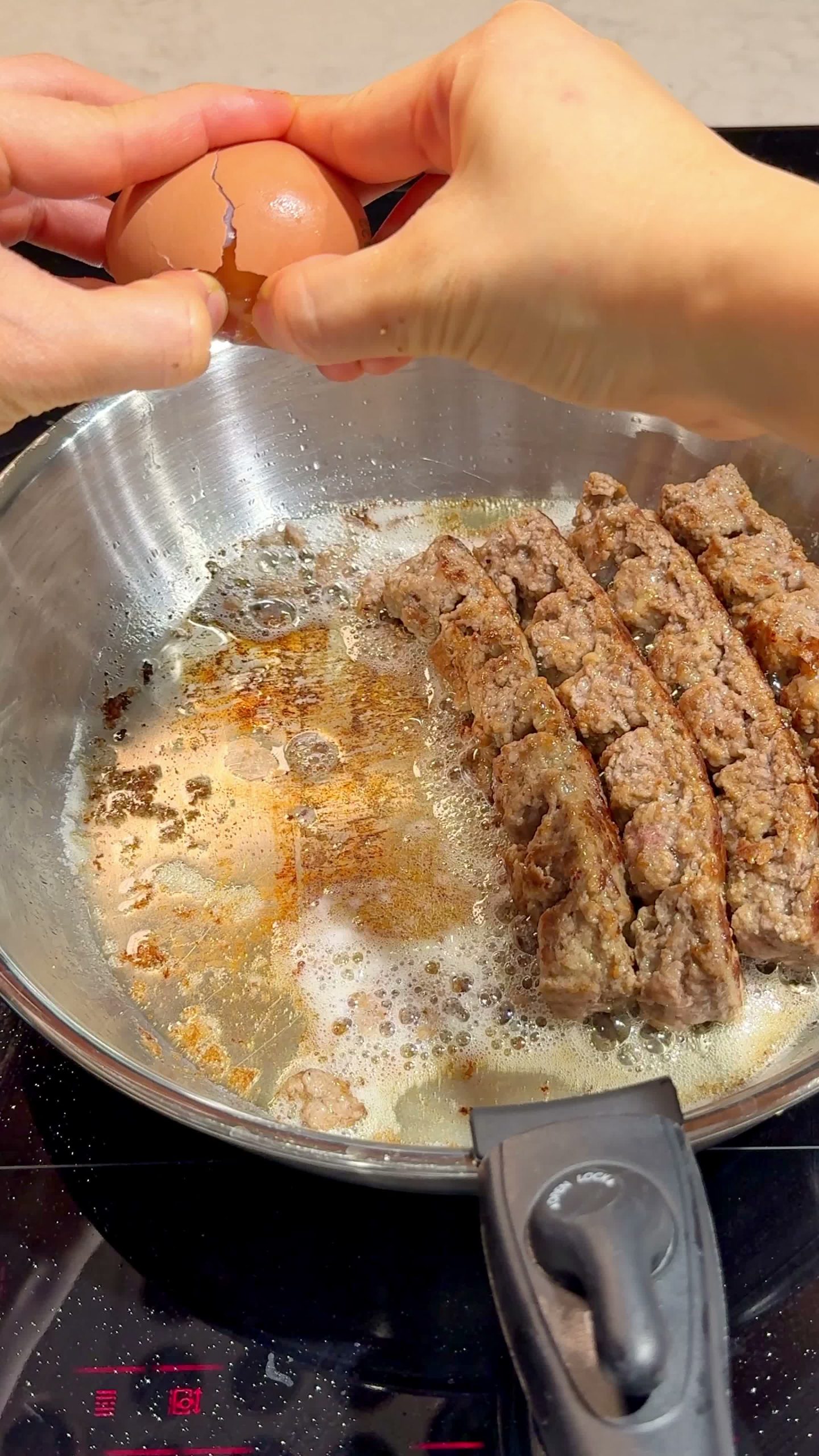 Cutting a meatball in half in the pan to brown the cut side