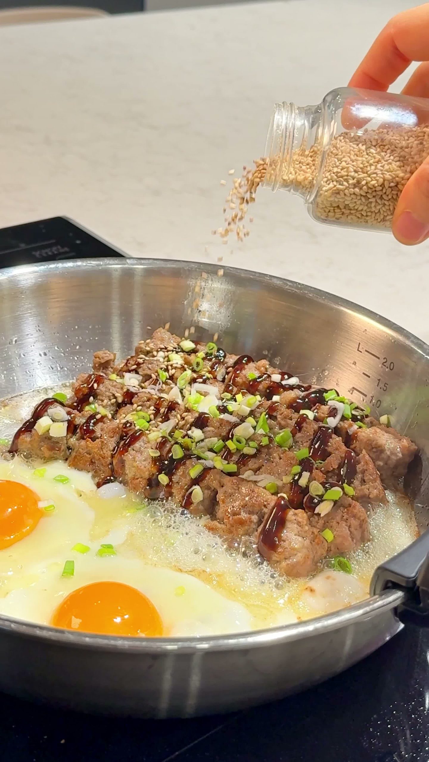 Cracking an egg into the pan next to the meatballs and spinach
