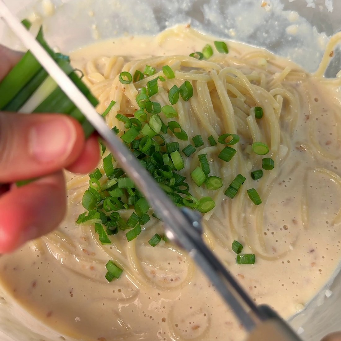 Cooked spaghetti tossed with butter and green onions