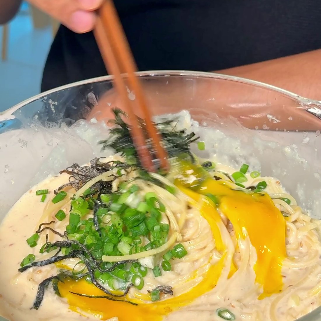 Pasta mixed with sauce and topped with egg yolk and nori