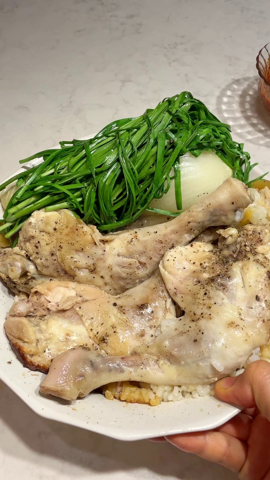 No-water baeksuk chicken and rice plated with garlic chives and dipping sauce