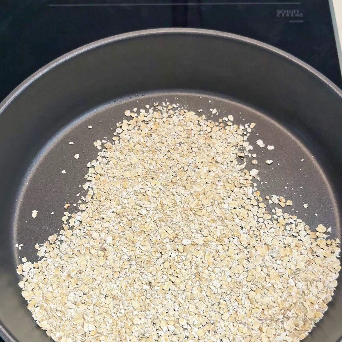 Oatmeal spread across the non-stick pan