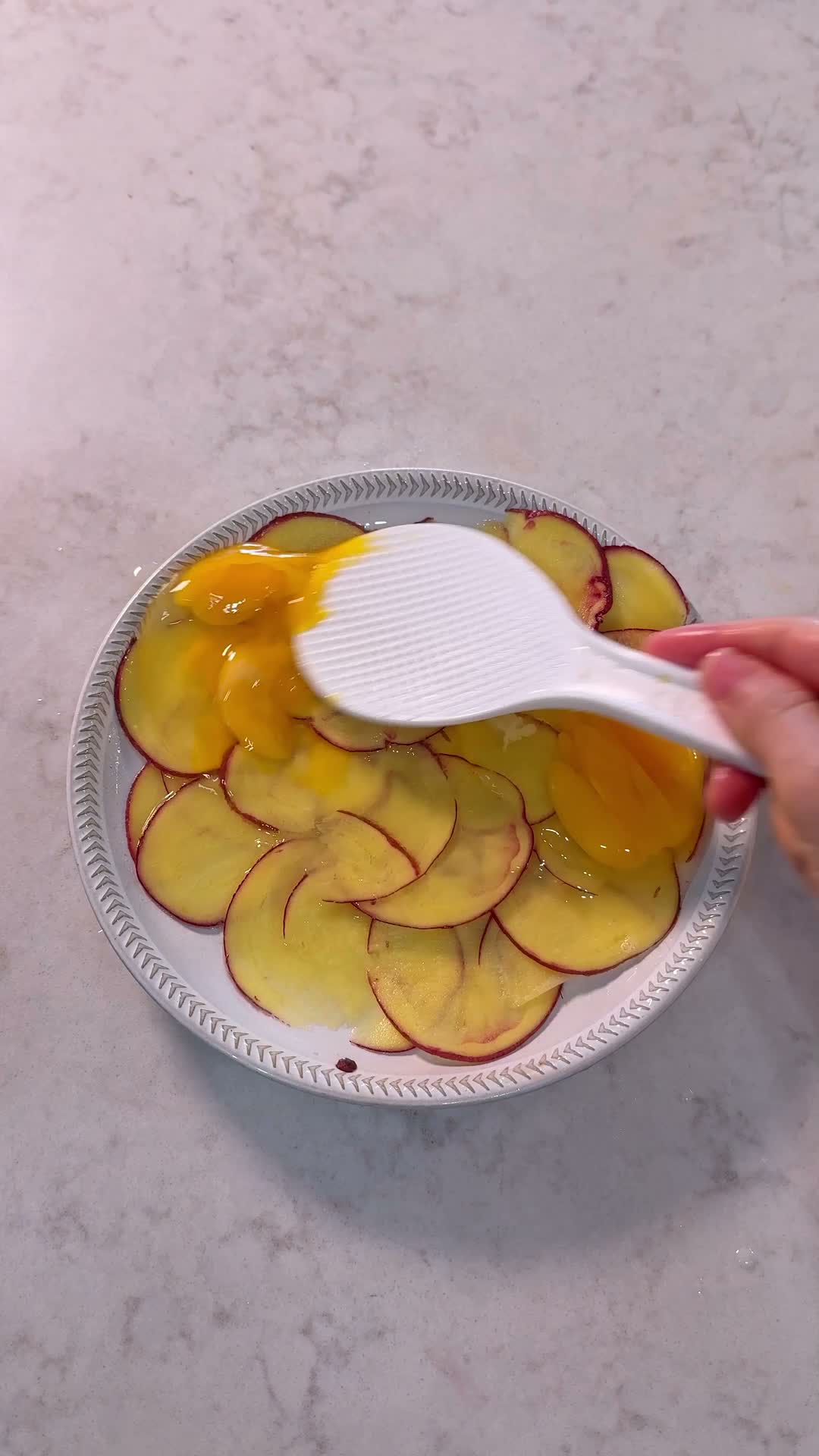 Egg poured over layered potato slices before microwaving