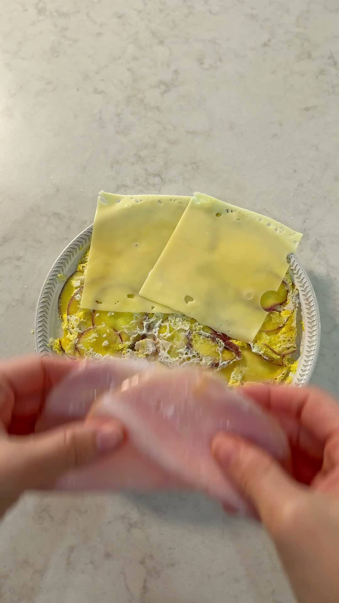 Adding ham to the cooked potato egg sheet before folding