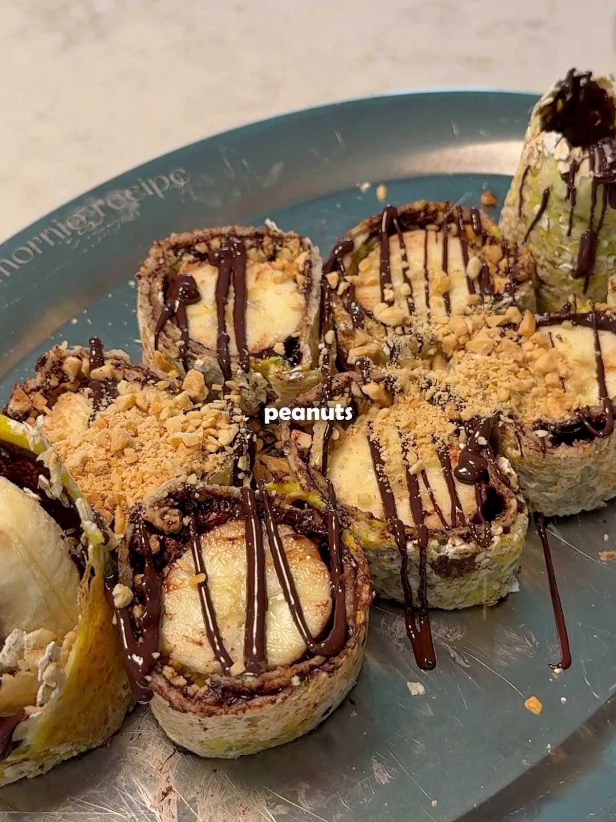 Sliced oats crepe pinwheels with chocolate drizzle and crushed peanuts