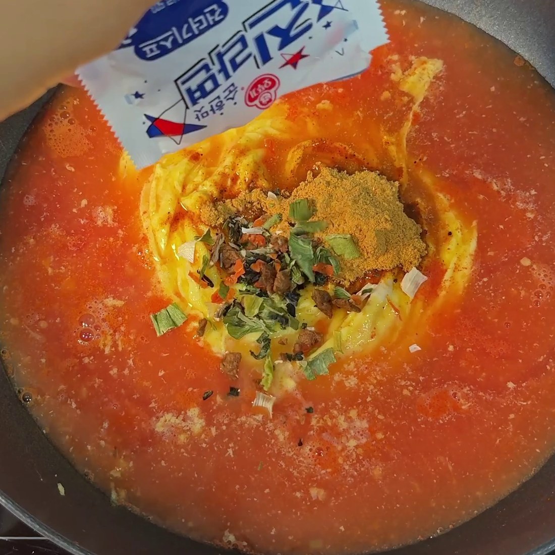 Ramen seasoning packet added into a well in the center
