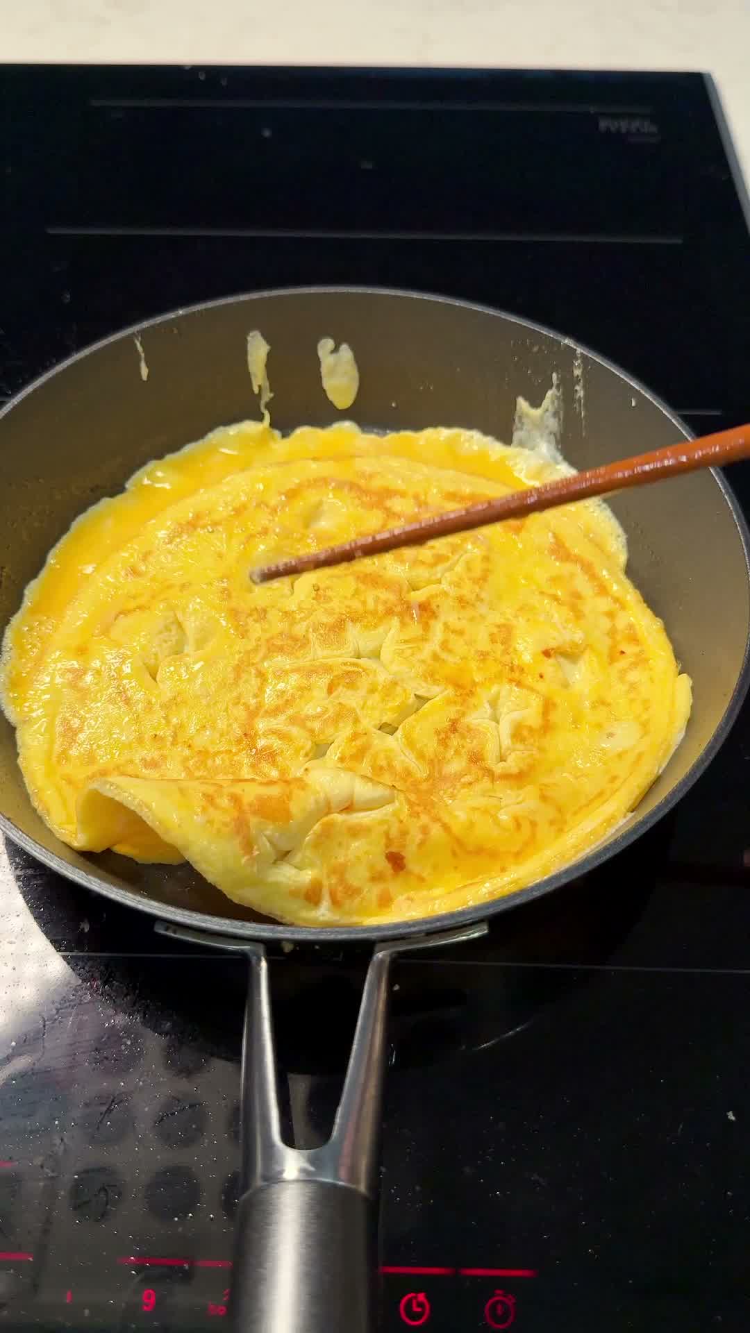 A thin whole egg sheet cooking flat in the pan