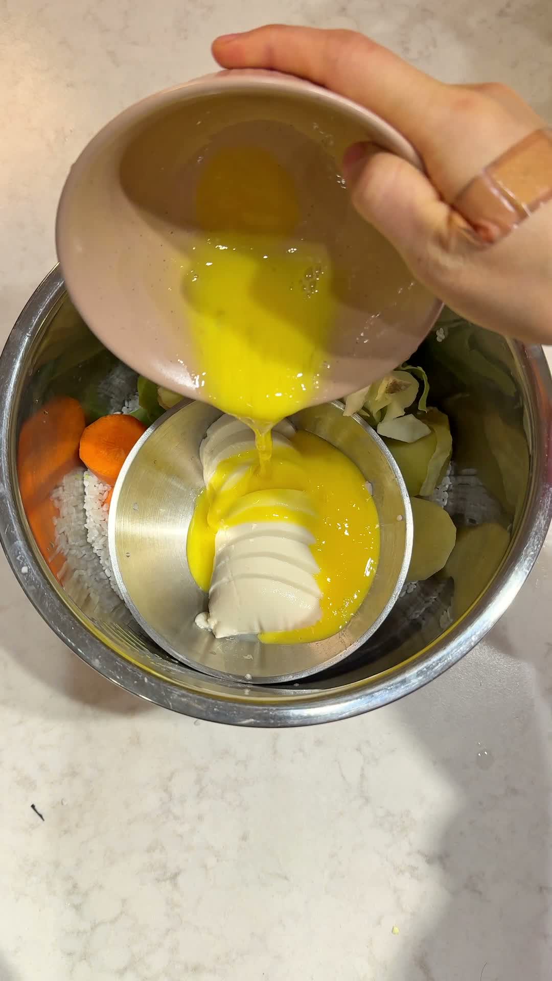 Rice, carrots, potato, cabbage, tofu, and egg combined in the pot