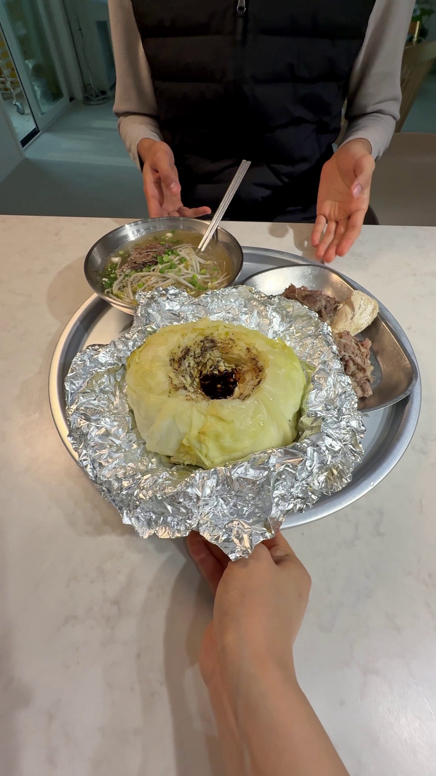 Steamed whole cabbage filled with soy butter sauce and a piece of meat