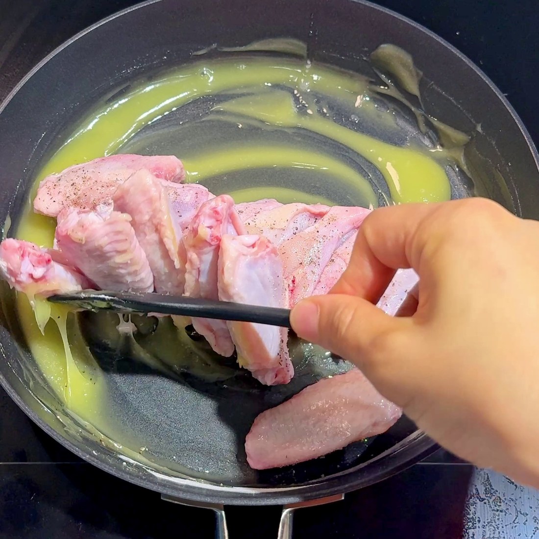 Chicken wings seasoned and spread out in the pan