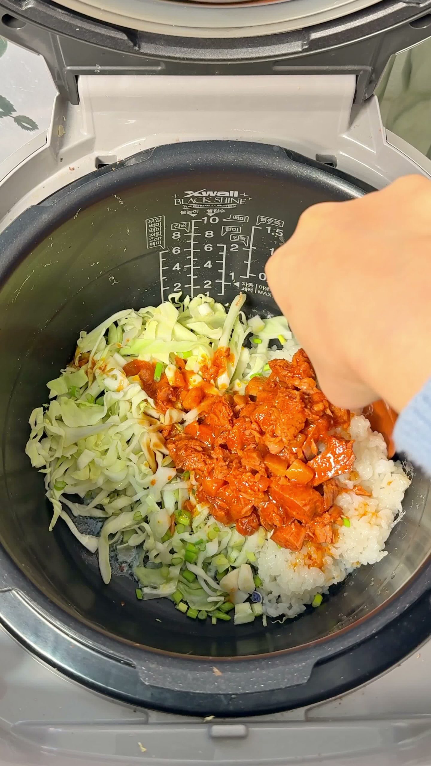 Cold rice, cabbage, and canned spicy tuna added to the rice cooker, not yet mixed