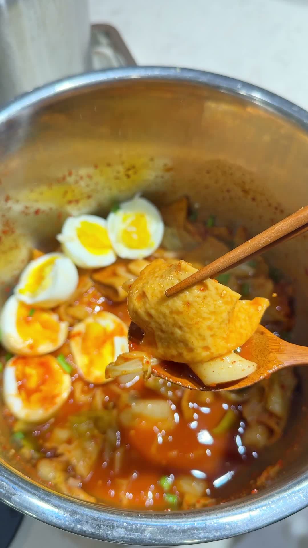 Finished tteokbokki plated into two bowls with soft-boiled eggs